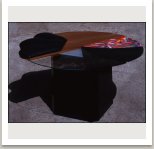 Stůl z různých materiálů (polstrování, sklo, plech, mramor, světlo, pomalované dřevo), 1983, 75x145x145 cm